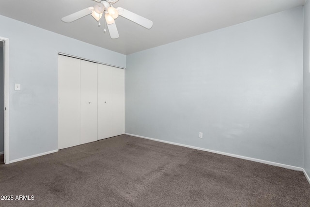 unfurnished bedroom featuring dark colored carpet, ceiling fan, and a closet