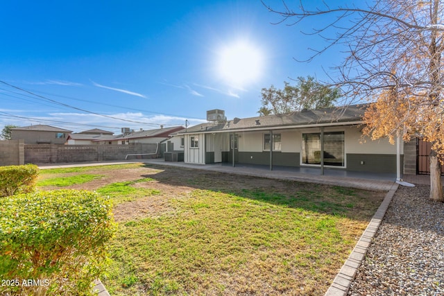 back of property featuring a patio area and a yard