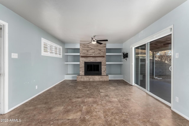 unfurnished living room with a large fireplace, built in features, and ceiling fan