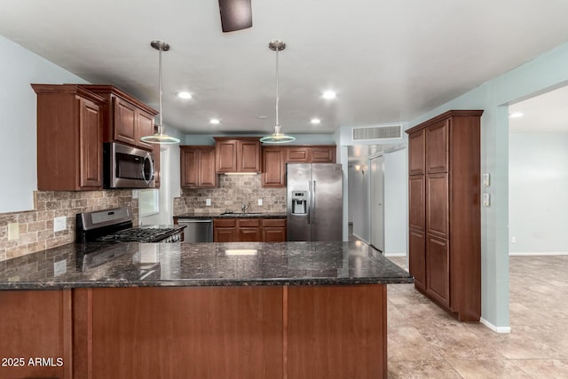 kitchen with pendant lighting, backsplash, sink, appliances with stainless steel finishes, and kitchen peninsula