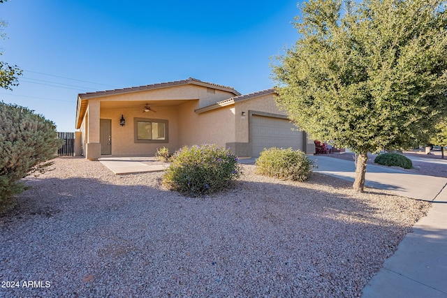 view of front of home featuring ceiling fan and a garage