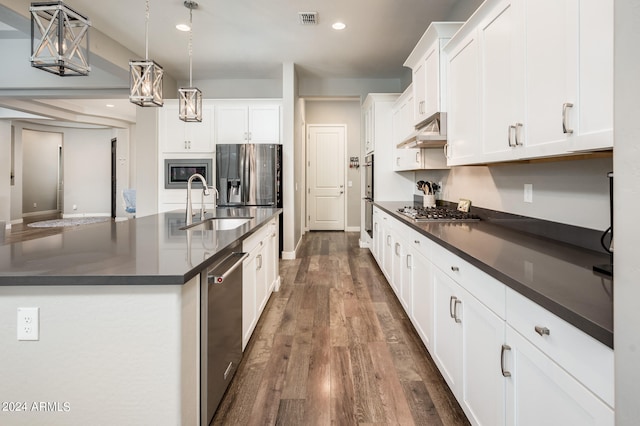 kitchen featuring pendant lighting, white cabinetry, a center island with sink, appliances with stainless steel finishes, and dark hardwood / wood-style flooring