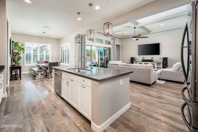 kitchen featuring ceiling fan, white cabinets, an island with sink, sink, and light hardwood / wood-style flooring