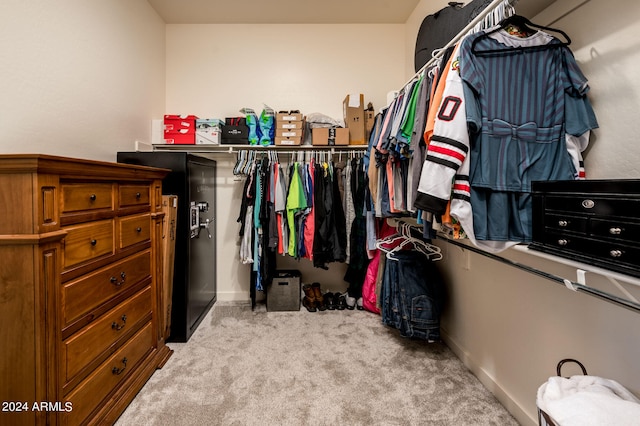 walk in closet featuring light colored carpet