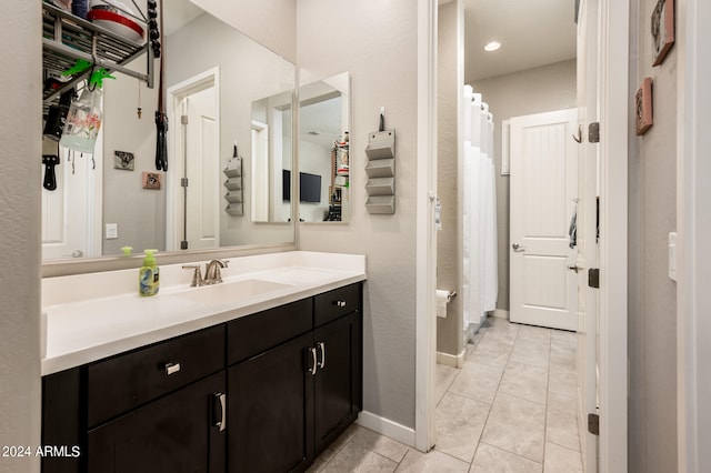 bathroom with tile patterned flooring, walk in shower, and vanity