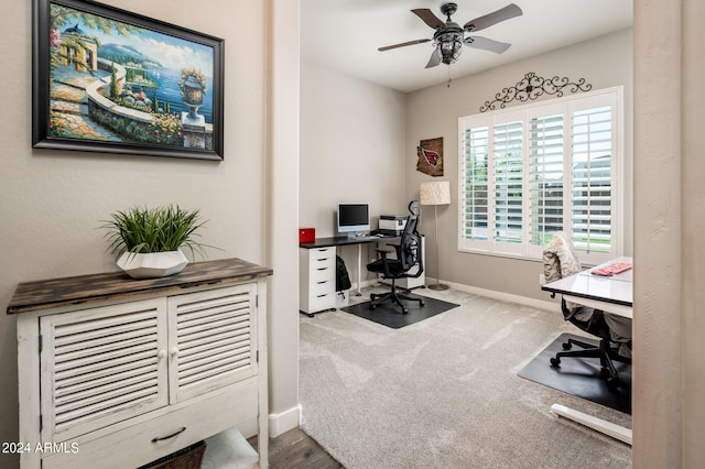 carpeted office space with ceiling fan