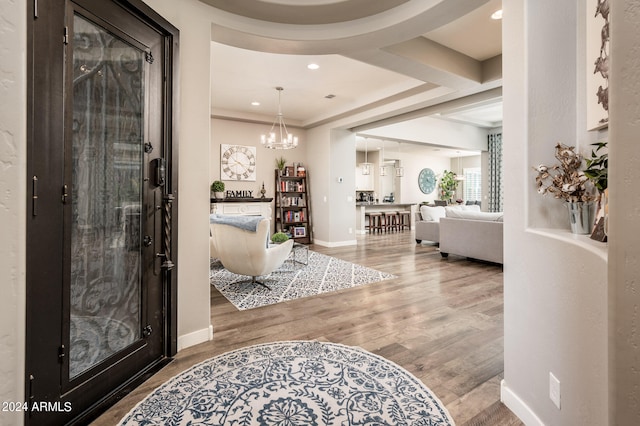 entryway featuring hardwood / wood-style flooring and a notable chandelier