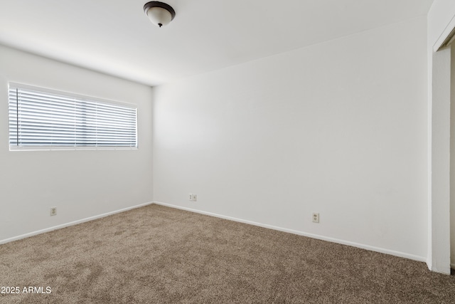 carpeted empty room with baseboards