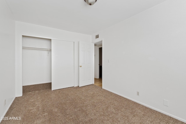 unfurnished bedroom with carpet flooring, a closet, and baseboards