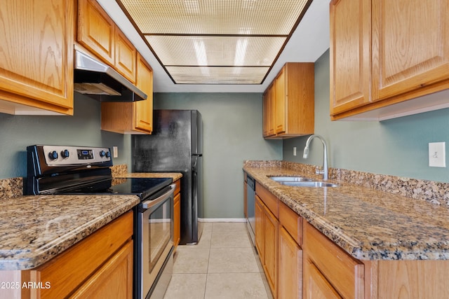 kitchen featuring appliances with stainless steel finishes, under cabinet range hood, a sink, light stone countertops, and light tile patterned flooring