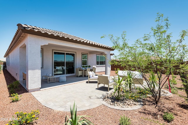 rear view of property featuring an outdoor living space and a patio area