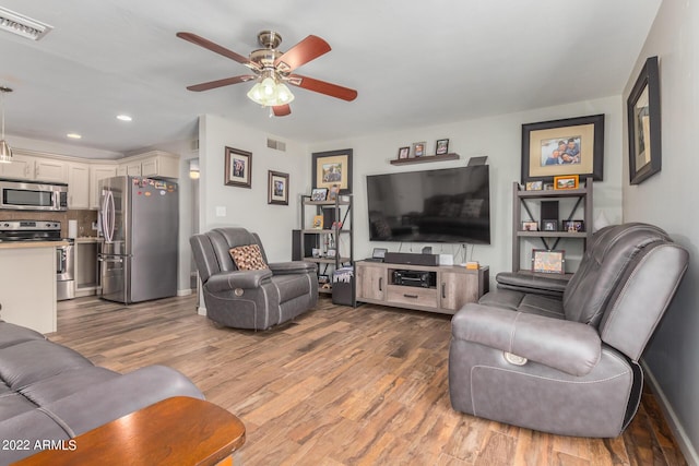 living area with light wood-type flooring, ceiling fan, visible vents, and recessed lighting