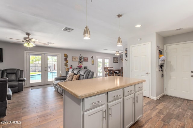 kitchen with open floor plan, visible vents, french doors, and wood finished floors