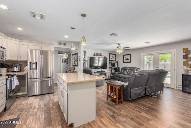 kitchen featuring visible vents, appliances with stainless steel finishes, light countertops, and open floor plan