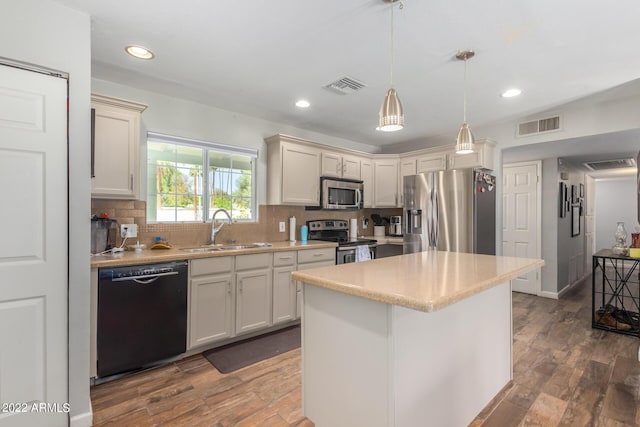 kitchen featuring tasteful backsplash, light countertops, visible vents, appliances with stainless steel finishes, and a sink