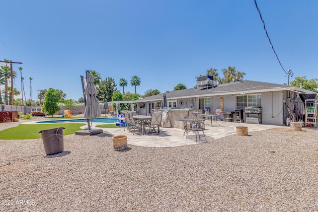 back of house featuring fence, a fenced in pool, and a patio