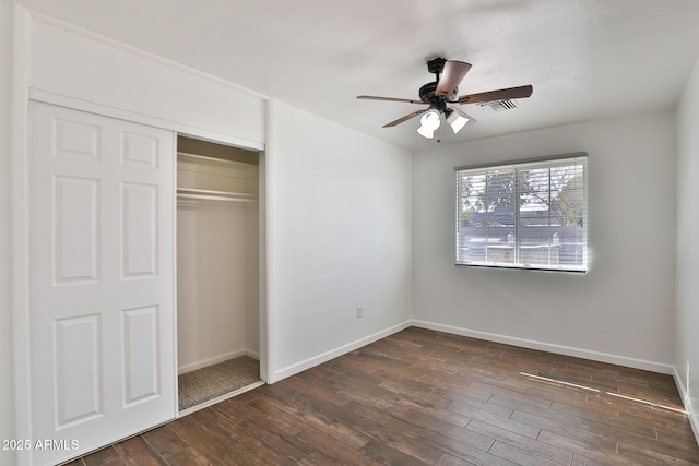 unfurnished bedroom with ceiling fan, visible vents, baseboards, a closet, and dark wood finished floors