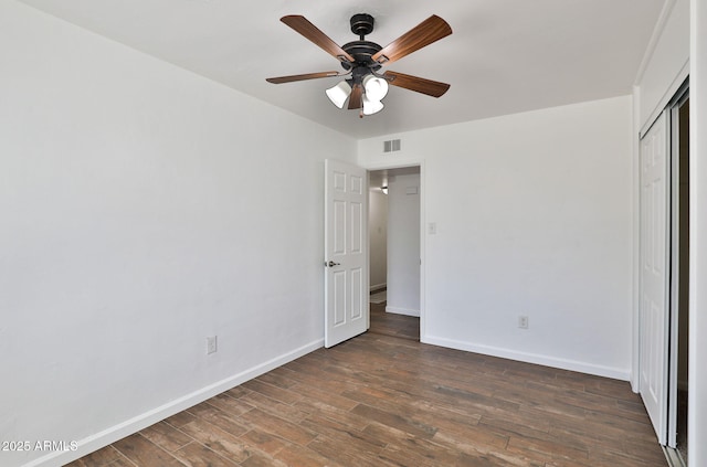 unfurnished bedroom featuring visible vents, a closet, baseboards, and wood finished floors