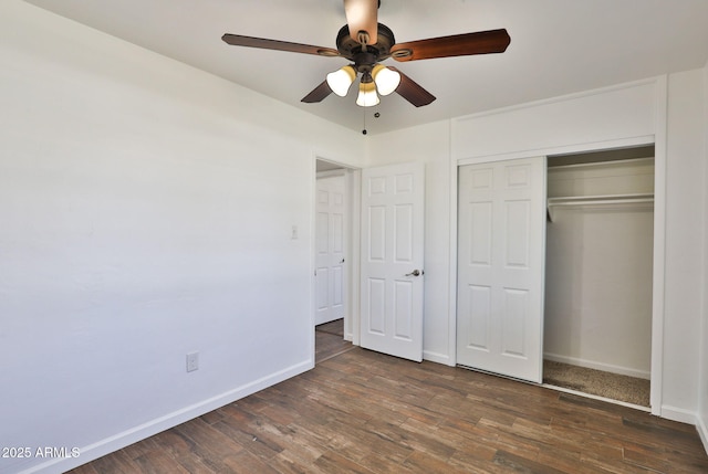 unfurnished bedroom with a closet, wood finished floors, and baseboards