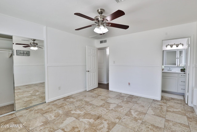 unfurnished bedroom featuring visible vents, baseboards, a ceiling fan, ensuite bathroom, and a closet