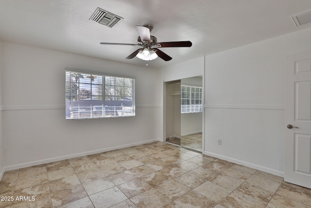 unfurnished bedroom featuring baseboards, visible vents, ceiling fan, and a closet