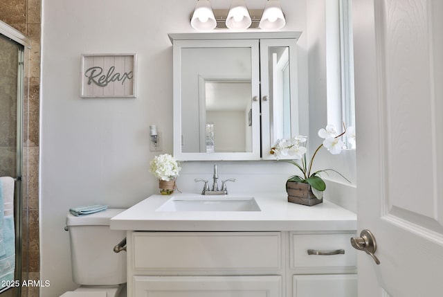 full bathroom featuring tiled shower, vanity, and toilet