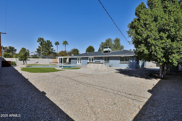 view of front facade featuring a fenced in pool, a fenced backyard, and a patio