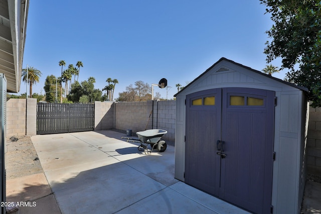 view of patio / terrace featuring a storage unit, an outdoor structure, and a fenced backyard