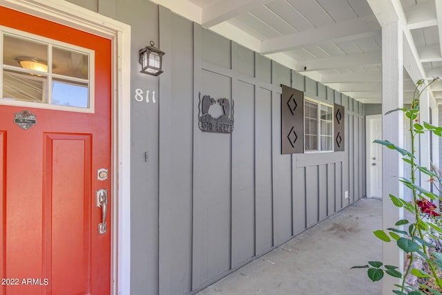 doorway to property with covered porch and board and batten siding