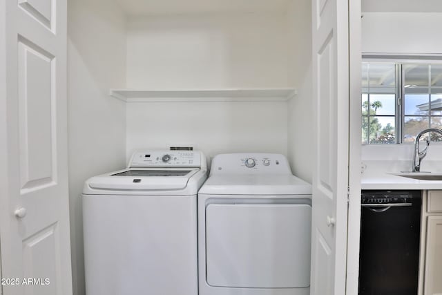 laundry area with washing machine and dryer and a sink