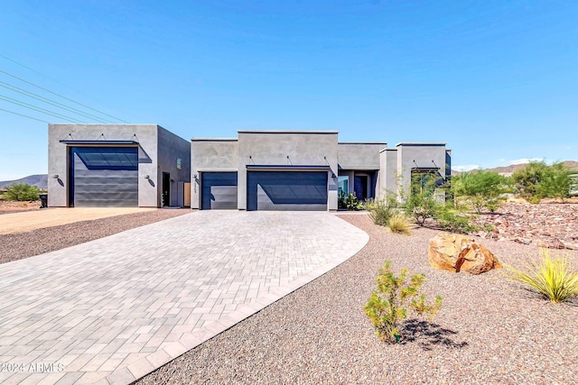 view of front of home featuring a garage, decorative driveway, and stucco siding