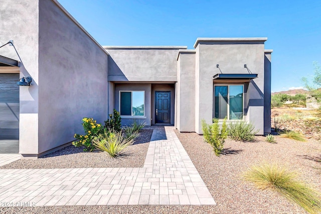 view of exterior entry with stucco siding