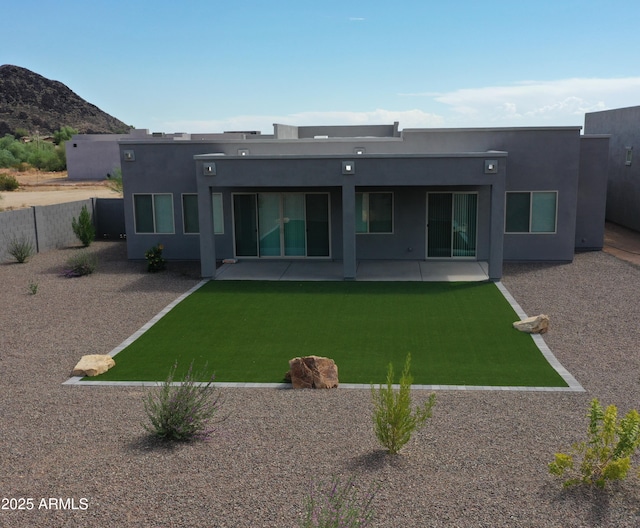 back of property with a yard, fence, a patio, and stucco siding