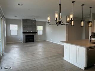 interior space featuring a large fireplace, hardwood / wood-style flooring, sink, and a chandelier