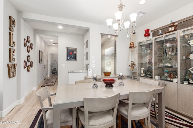 living room featuring ceiling fan with notable chandelier and light hardwood / wood-style floors