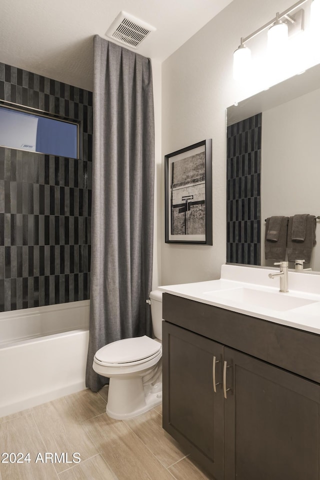 full bathroom featuring vanity, shower / tub combo, and toilet