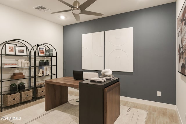 home office with light wood-type flooring and ceiling fan