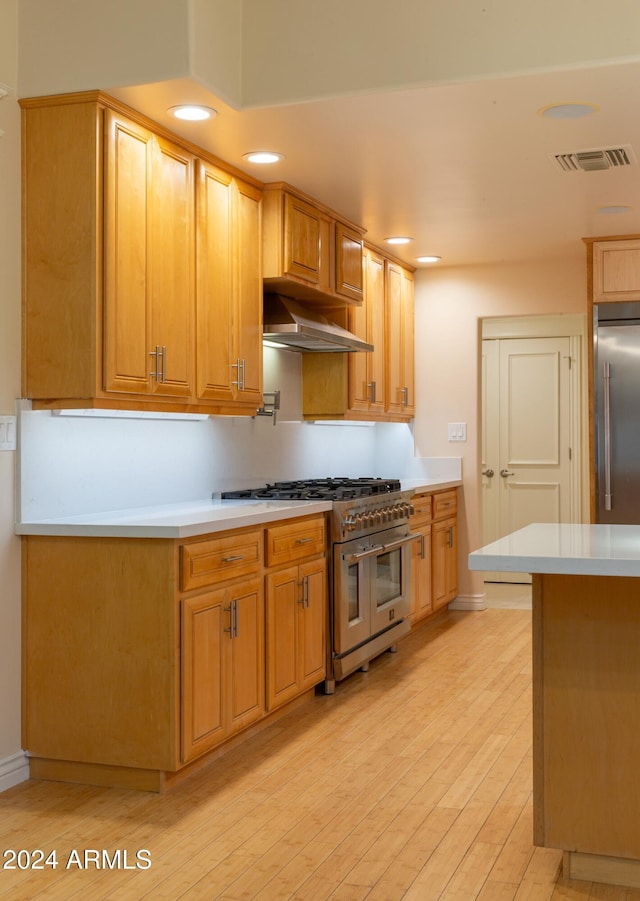 kitchen with high quality appliances and light hardwood / wood-style flooring