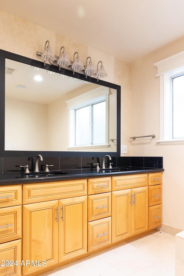 bathroom featuring double sink and a wealth of natural light