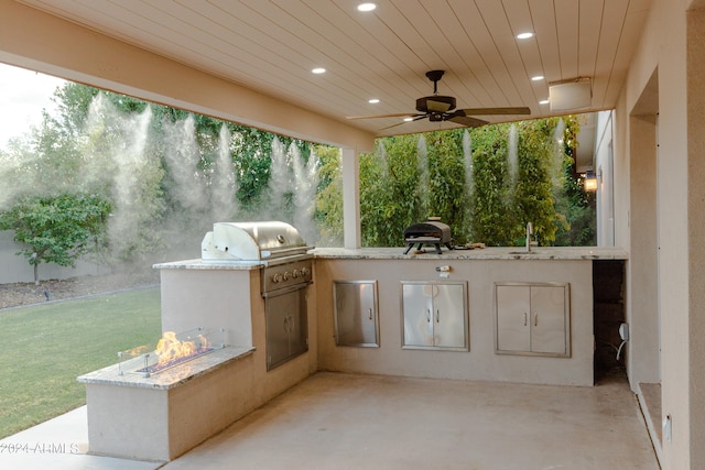 view of patio featuring ceiling fan, an outdoor kitchen, and sink