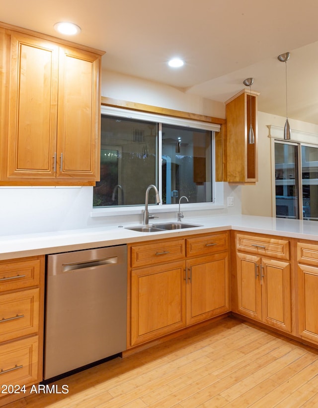 kitchen with light wood-type flooring, hanging light fixtures, dishwasher, and sink