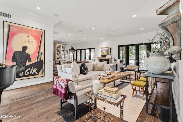 living room with ceiling fan, wood-type flooring, and ornamental molding