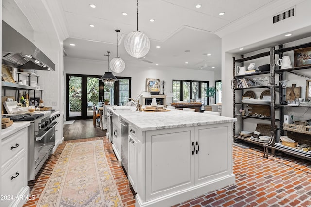 kitchen featuring french doors, stainless steel appliances, an island with sink, decorative light fixtures, and white cabinets