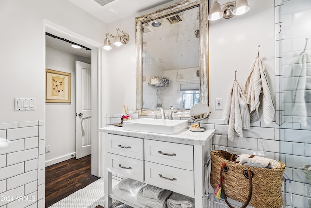 bathroom featuring a shower, vanity, tile walls, and hardwood / wood-style flooring