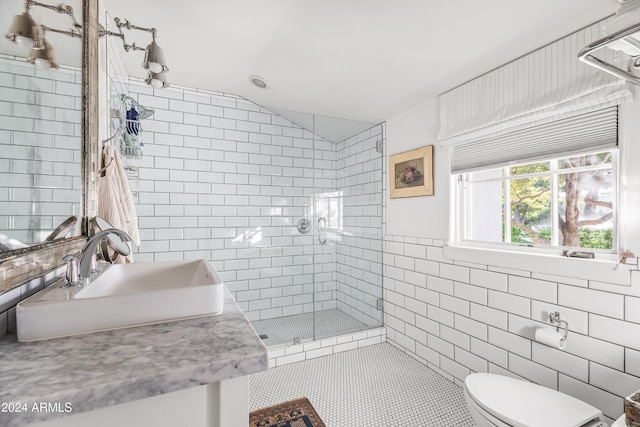 bathroom with a shower with shower door, vanity, tile walls, toilet, and lofted ceiling