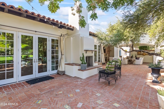 view of patio / terrace featuring french doors and an outdoor fireplace