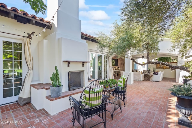 view of patio / terrace featuring french doors and an outdoor fireplace