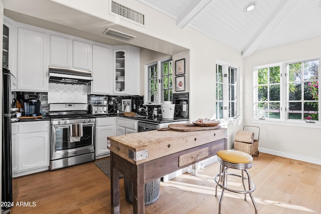 kitchen with decorative backsplash, light wood-type flooring, dishwasher, stainless steel stove, and white cabinetry