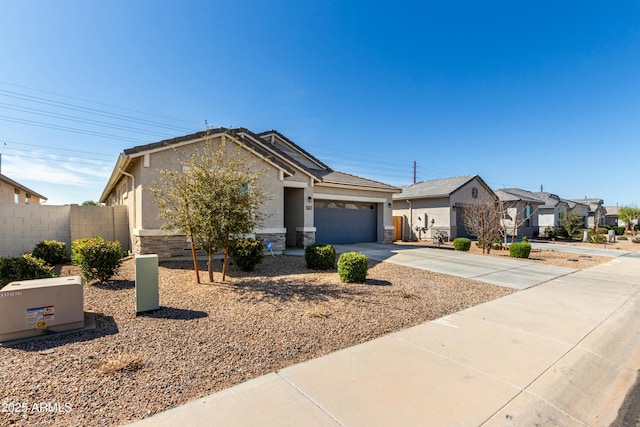 single story home featuring fence, concrete driveway, stucco siding, stone siding, and an attached garage