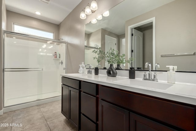 full bathroom featuring tile patterned floors, a shower stall, double vanity, and a sink